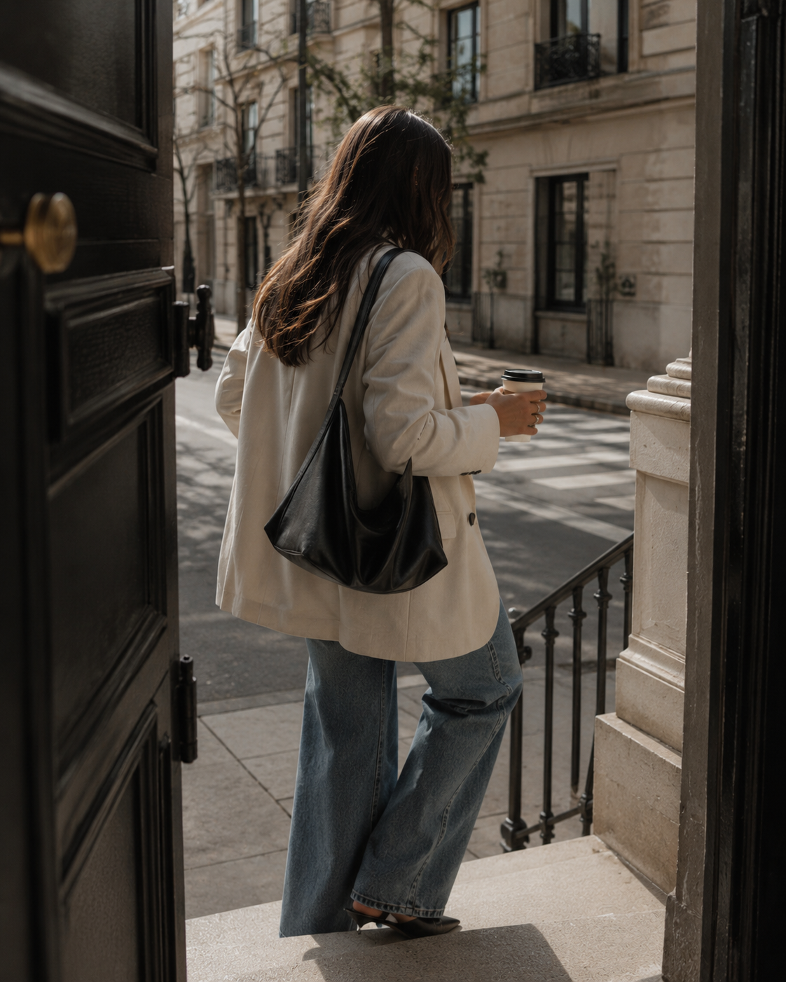 A woman stepping from an apartment onto a city street